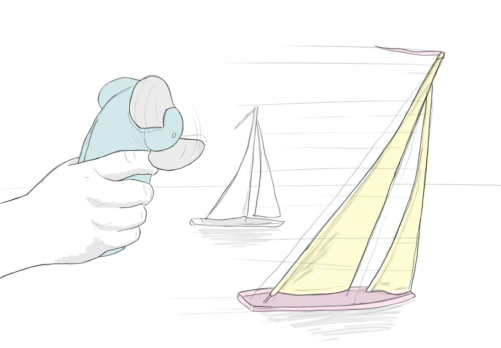 A hand with a motorized fan creates wind to push two sailboats