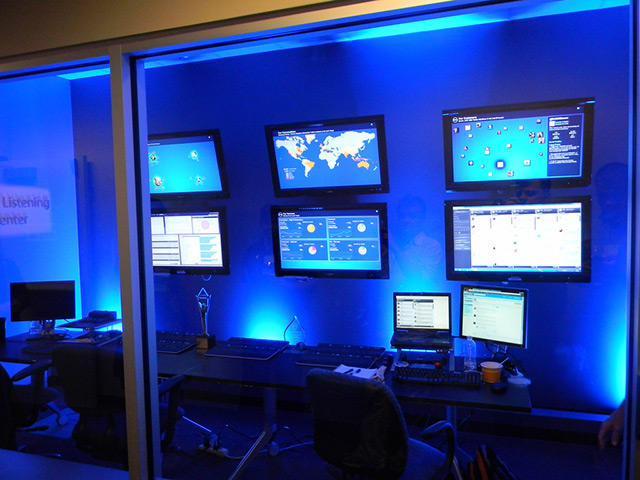 8 monitors insides a room tinted blue