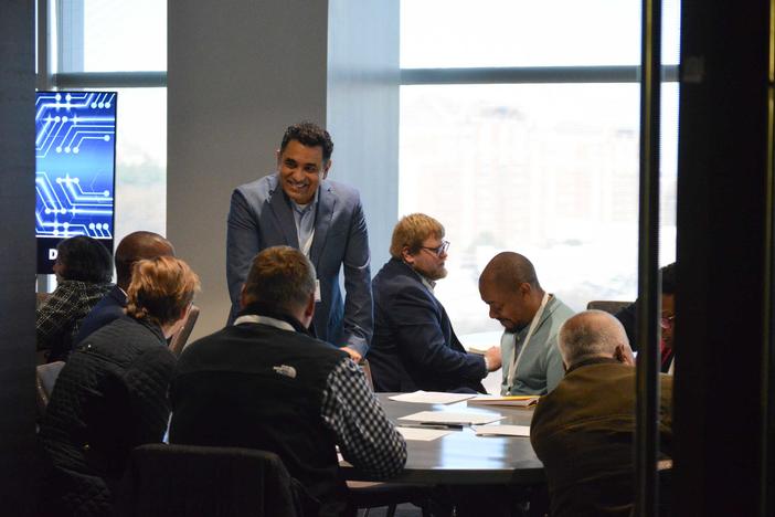 Nikhil talking with attendees between sessions at the AI summit.